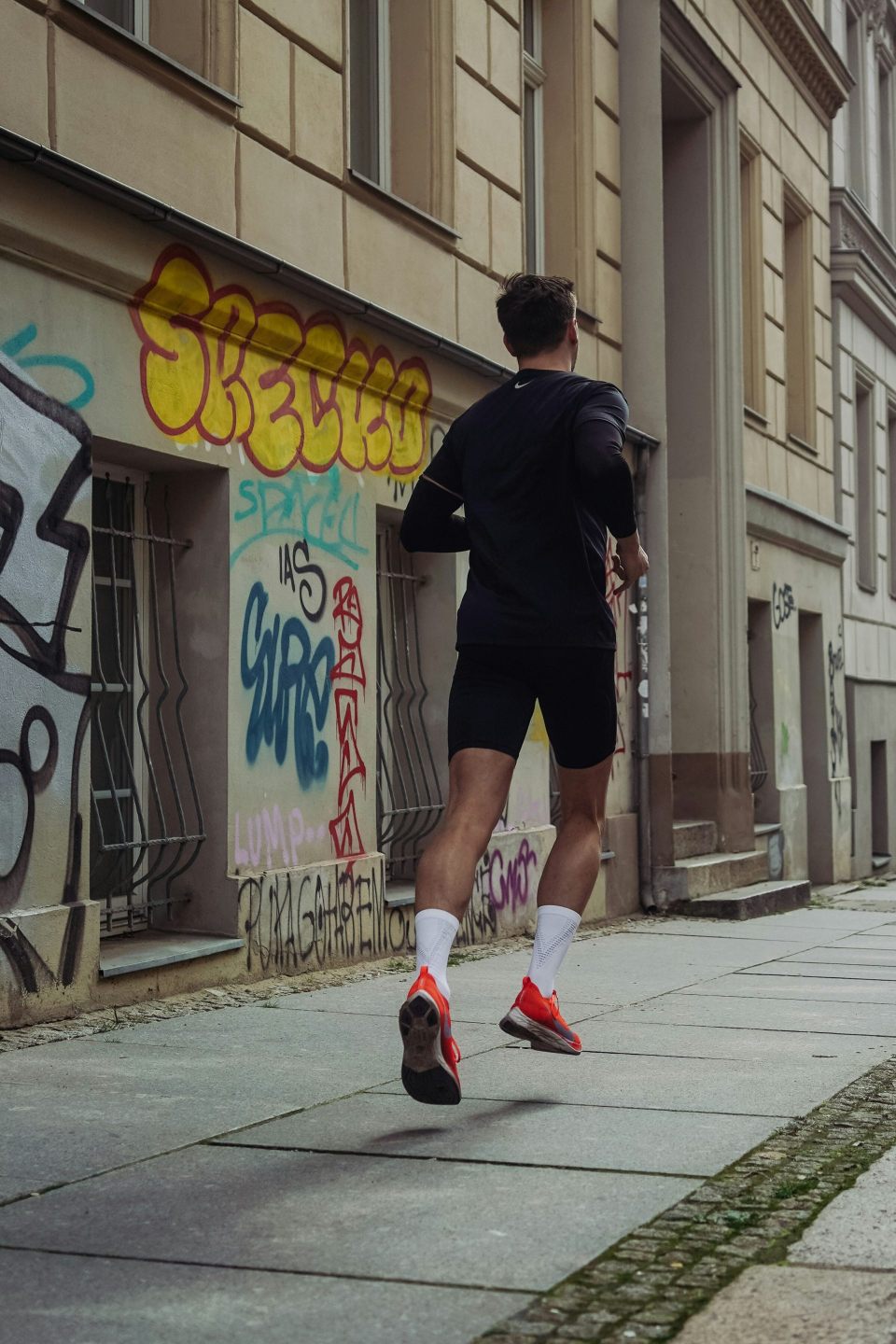 Runner near graffiti-covered wall